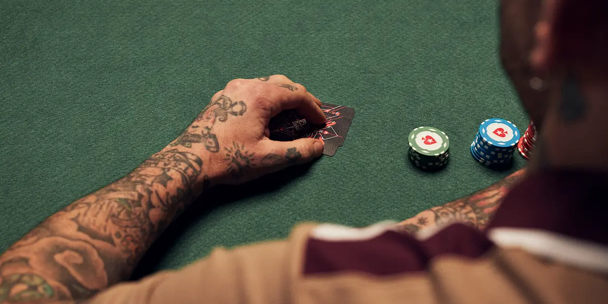  Jogador de poker segurando suas cartas próprias em um jogo de poker ao vivo 