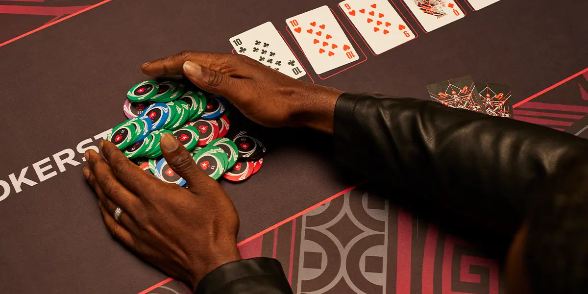 Jogador de poker pegando as fichas após ganhar um pote na mesa 