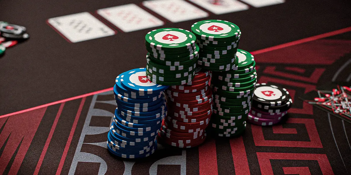 Visualização detalhada das fichas de poker sendo empurradas no pote, representando o risco de exagerar com mãos medíocres no turn.